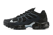 Side view of a black Nike sneaker with a wavy cage, visible cushioning and speckled sole.