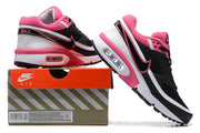Black, white and pink Nike Air Max BW-style sneakers shown beside a shoebox.
