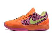 Side profile of an orange Jordan basketball sneaker with a pink patterned panel, lime swoosh-style detail, and textured outsole.