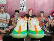 Front view of white low-top Converse basketball shoes with orange center details and green and turquoise accents