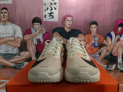 Front view of beige and black Nike running shoes with laces, mesh-looking uppers, and black toe-side swooshes.