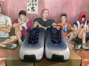 Front view of the Nike sneakers showing dark laces, white toe sections, patterned blue uppers, and black toe outsole areas.