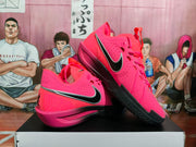 Angled side view showing the pink perforated upper, black and silver Swoosh, and layered pink-and-black sole.