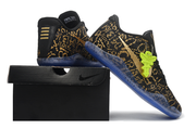 Black and gold Kobe 11 shoes posed on a black shoe box