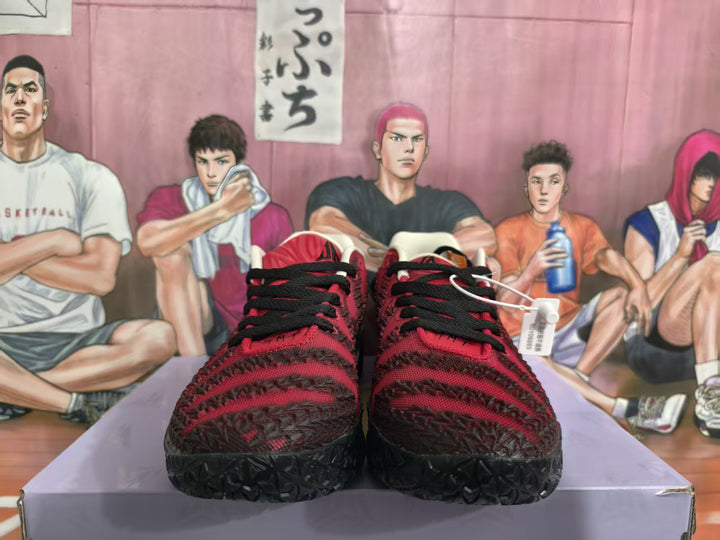 Front view of red and black textured sneakers with black laces and patterned black outsoles.
