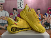 Angled view of paired yellow basketball sneakers showing the patterned collar lining, side details, and sculpted soles.