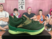Side view of a green sneaker with a gold-patterned overlay, gold accent, and “FLOW” marking on the midsole.
