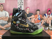 Side view showing the gold Nike swoosh, multicolor graphic panels, black patterned upper, and translucent green outsole.