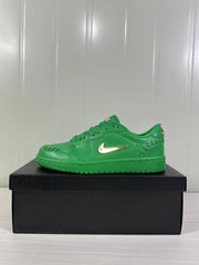 Side profile of a green low-top sneaker with gold Swoosh branding on a black box.