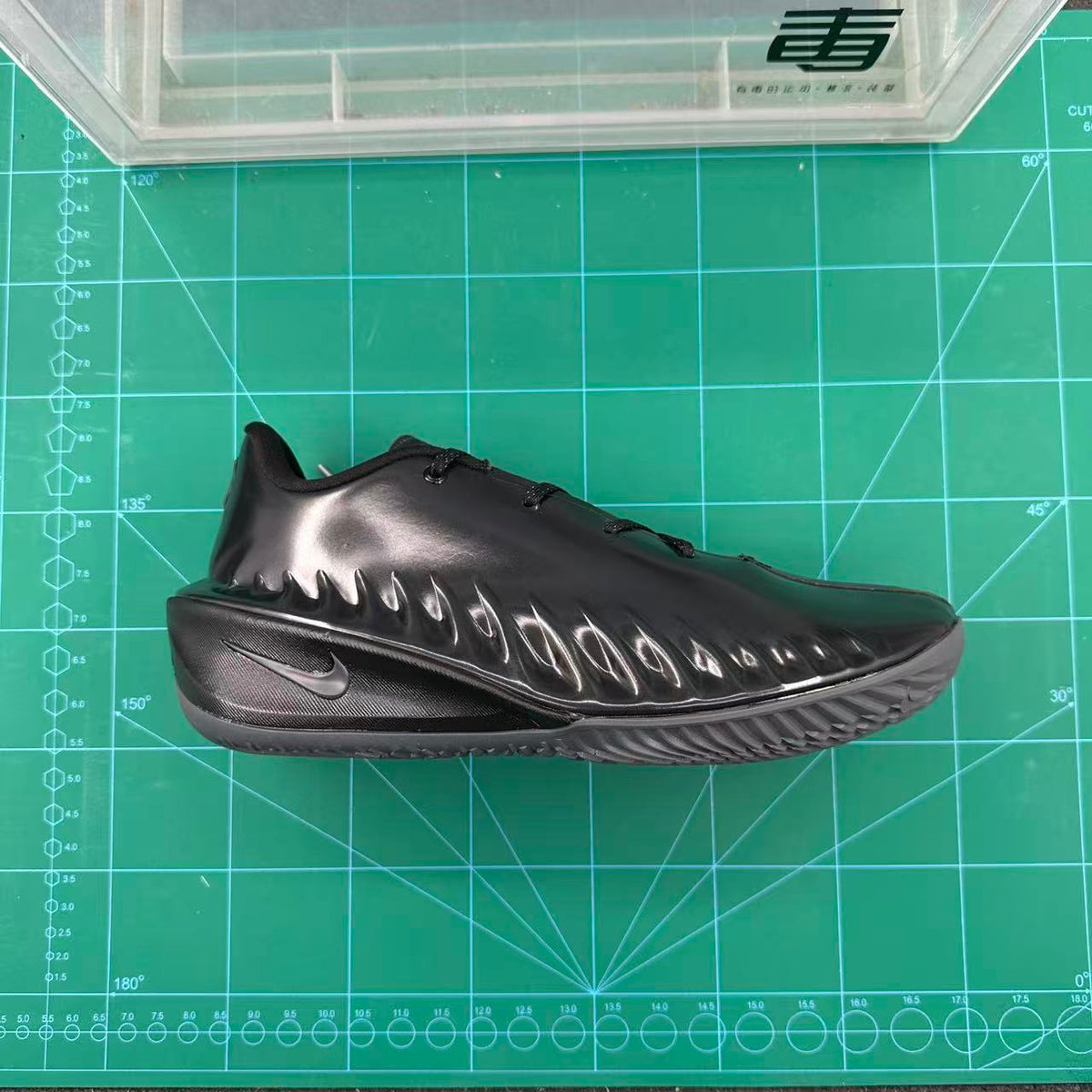 Side view of a black Nike GT basketball shoe with a sculpted glossy upper and patterned outsole.