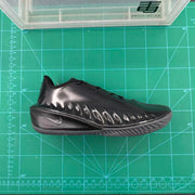 Side view of a black Nike GT basketball shoe with a sculpted glossy upper and patterned outsole.