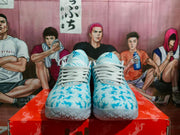 Front view showing the matching pair of light blue Nike basketball sneakers with white laces and patterned tongues.