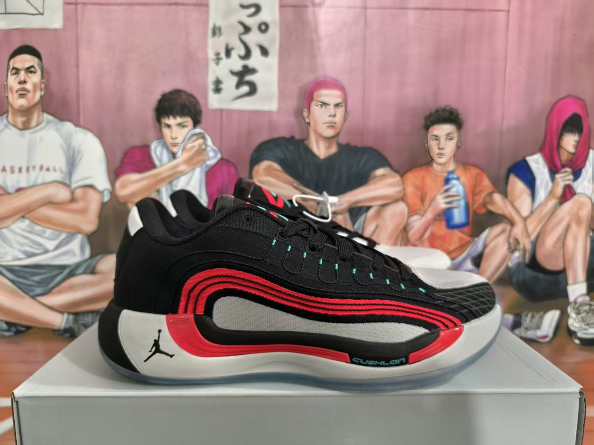 Side view of a black and red Jordan basketball sneaker displayed on a shoebox, showing the Jumpman logo, layered side design, and Cushlon branding.