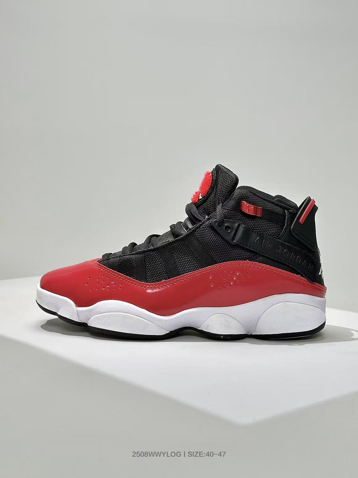 Side view of black and red high-top Jordan sneakers with a white midsole and black outsole.
