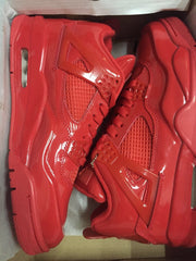 Red high-top sneakers placed inside an open box, showing the side panels and heel construction.