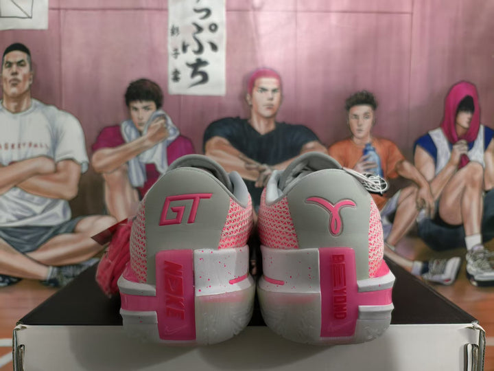 Rear view of grey and pink Nike basketball shoes showing GT branding and layered heel details.