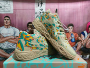 Angled side view of Puma sneakers showing layered side detailing, multicolor patterned panels, tonal laces, and sculpted soles.