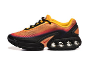 Side view of orange and pink Nike Air Max DN sneakers with black detailing and visible sole cushioning.