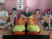 Front view of lime-green Nike basketball shoes with orange laces and accents