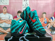 Pair of teal and black Nike basketball sneakers with red Swooshes displayed on a shoe box.