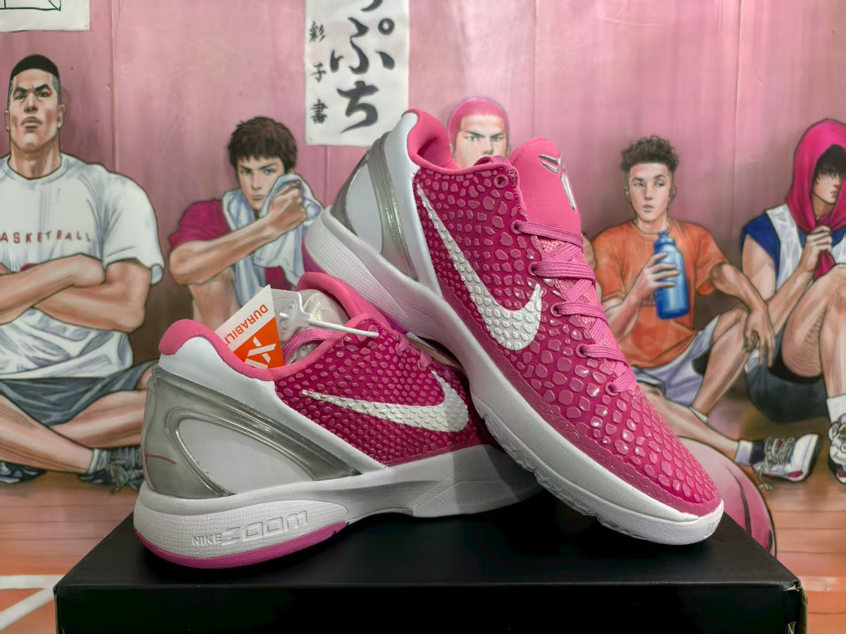 Pair of pink Nike basketball sneakers with silver swooshes and white midsoles shown from an angled side view.