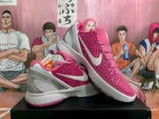 Pair of pink Nike basketball sneakers with silver swooshes and white midsoles shown from an angled side view.