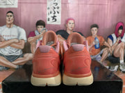 Rear view of the pair showing molded coral-orange heel sections, pink collar padding, cream midsoles, and heel signatures.