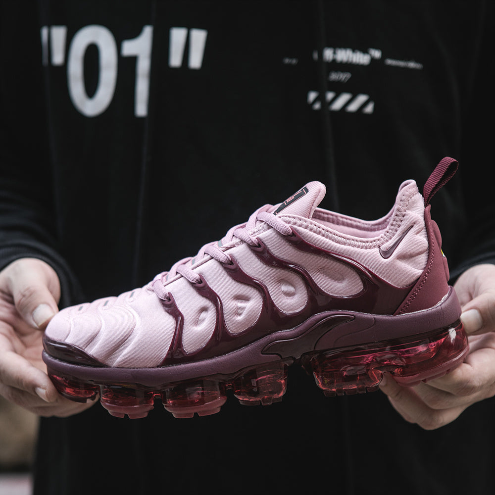 Close-up of a pink and plum Nike TN-18 sneaker with a translucent red-toned sole.