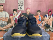 Front view of navy basketball shoes with yellow accents