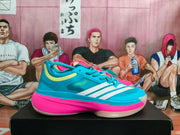 Side view of the blue sneaker showing white stripes, pale yellow accents, and a pink midsole.