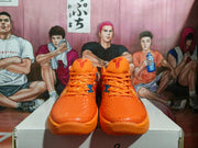 Front view showing the orange textured toe boxes, tonal laces, and tongue logos.