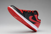 Side view of a black and red low-top Jordan sneaker with a white midsole and red outsole.