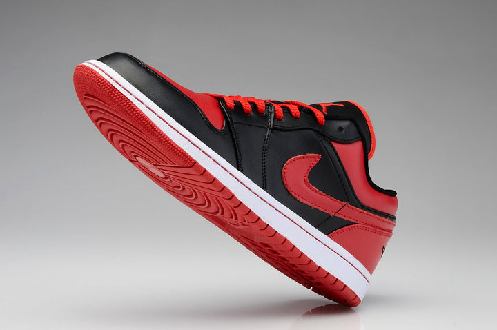 Side view of a black and red low-top Jordan sneaker with a white midsole and red outsole.