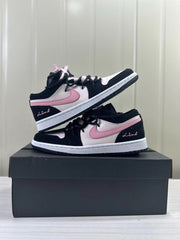 Two low-top sneakers arranged at an angle, showing pink side accents and ribbon details