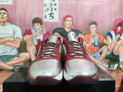 Front view showing perforated silver toe panels, patterned laces, and contrasting burgundy overlays.