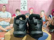 Rear view of black ASICS Gelhoop basketball shoes showing padded collars and heel details.