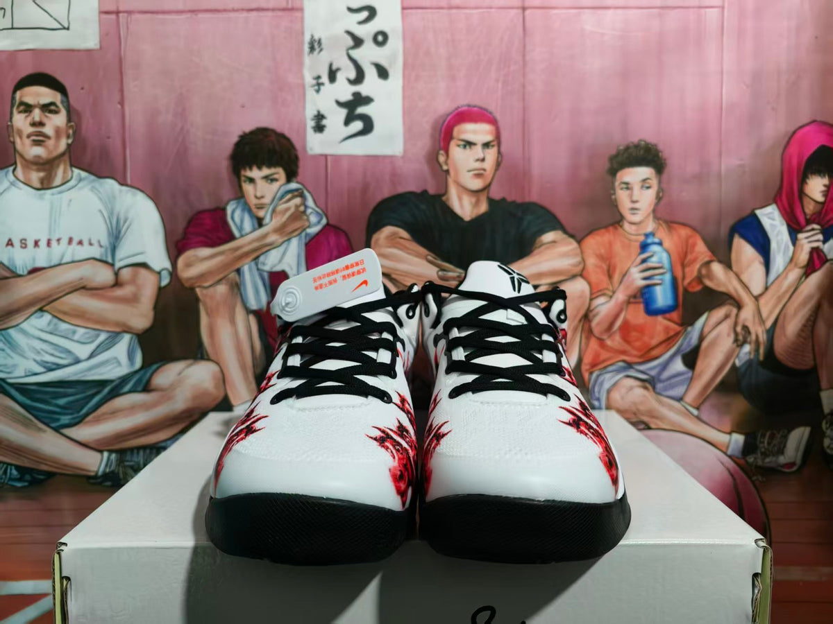 Front view of white, black, and red Nike basketball-style sneakers with black laces and red graphics.