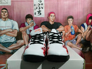 Front view of white, black, and red Nike basketball-style sneakers with black laces and red graphics.