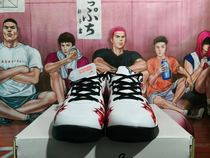 Front view of white, black, and red Nike basketball-style sneakers with black laces and red graphics.