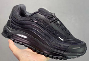 Black sneaker held in hand, shown from a side three-quarter angle.