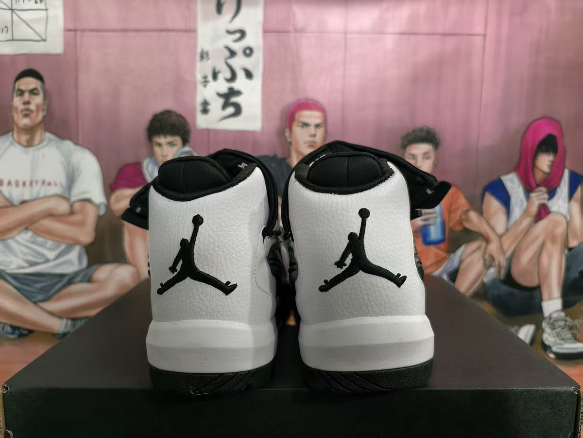 Rear view of white and black high-top sneakers showing the Jumpman logos and black heel panels.