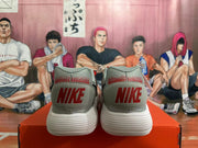 Rear view of gray Nike sneakers with red heel branding and white soles.