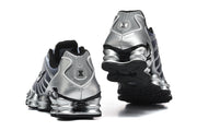 Rear and outsole views of silver Nike Shox TL sneakers with black detailing.