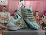 Pair of blue and gray Nike basketball sneakers with gold side branding, shown from an angled side view.