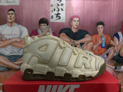 Side view of a beige Nike Air More Uptempo sneaker with oversized AIR lettering