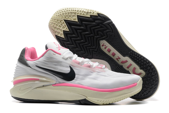 White and pink low-top basketball shoes with black accents, shown from the side and outsole.