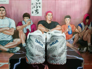 Rear view of gray Nike basketball sneakers with blue heel branding, textured panels, and patterned soles.