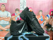 Pair of black Nike basketball sneakers displayed together, showing the silver Swoosh and textured outsole pattern.