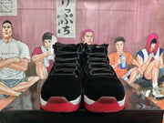 Front view of the pair showing black uppers, lace-up construction, red toe accents, and translucent red outsoles.