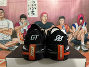 Rear view of black Nike basketball shoes with silver heel logos and orange heel accents.